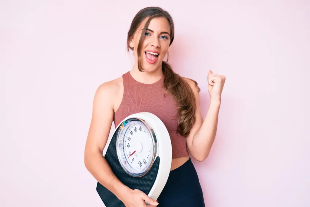 girl holding weighing scale